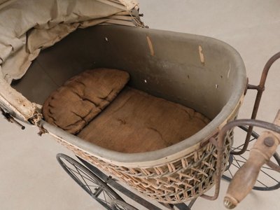 Antik barnevogn i flet og jern